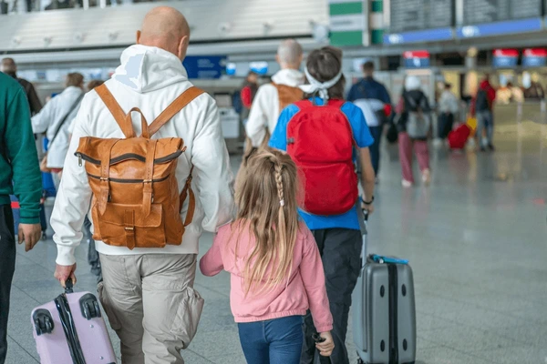 Famille avec valises à l'aéroport, choix d'assurance voyage Europe selon profil de voyageur